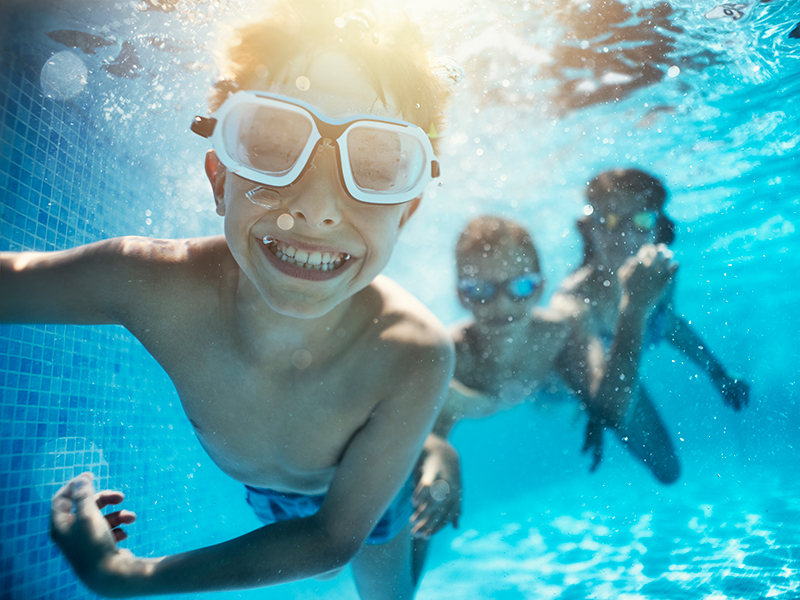 Kids swimming and smiling underwater 