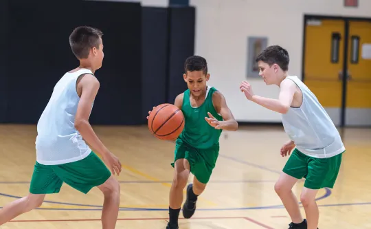 Three boys playing basketball