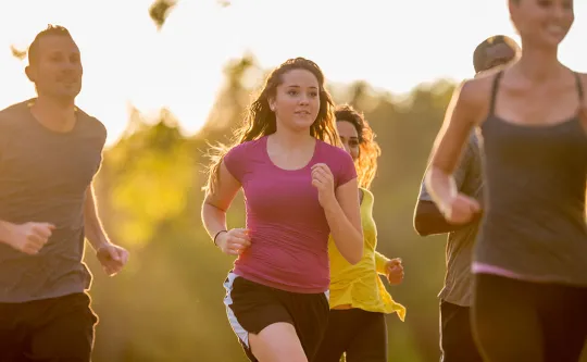 A group of people running outside in the sunsent at a YMCA Run Club meet up