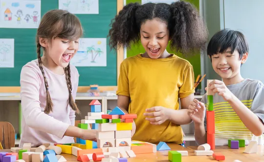 Three kids building a city with blocks