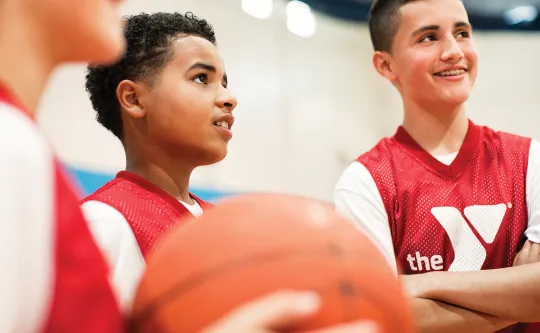 Group of boys talking to their coach at basketball practice