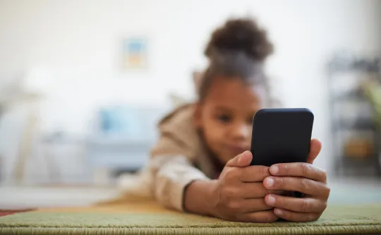 Adolescent girl looking at her cell phone 