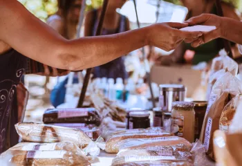 Someone pruchasing homemade bread at a vendor fair