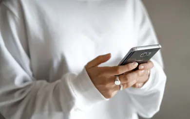 adult holding cell phone in the palm of hand