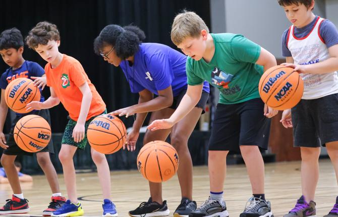 Group of kids learning dribble skills for basketball