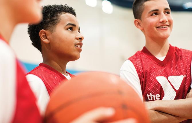 Group of boys talking to their coach at basketball practice